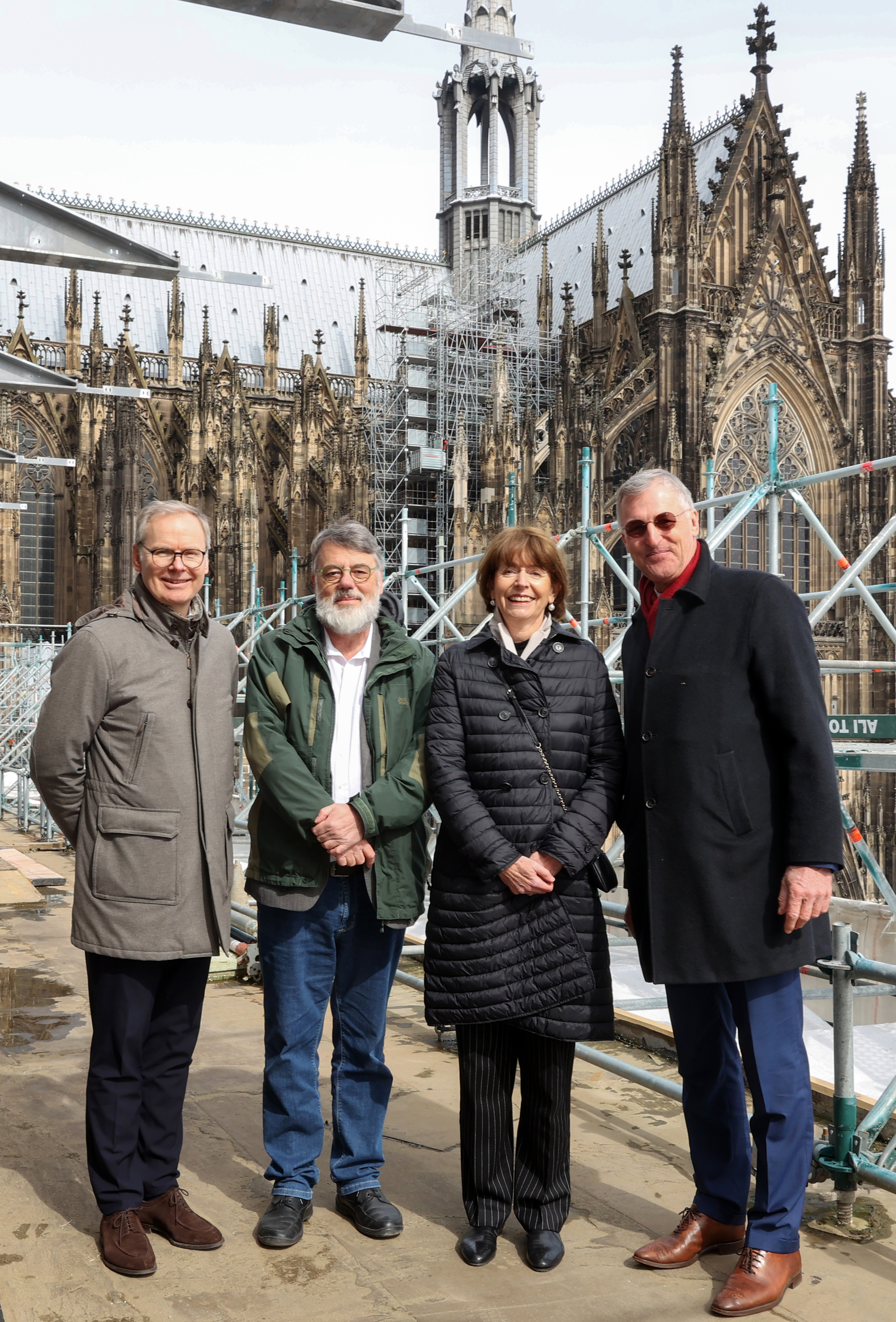 Foto mit vier Menschen auf der Baustelle des Domcarré vor dem Kölner Dom